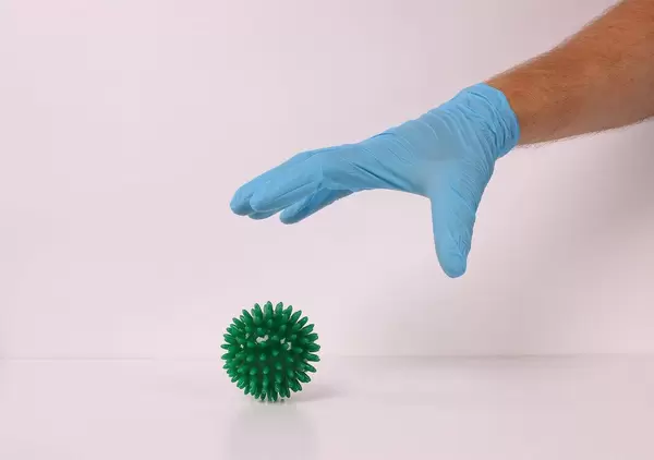 Hand in medical glove catching coronavirus bacteria