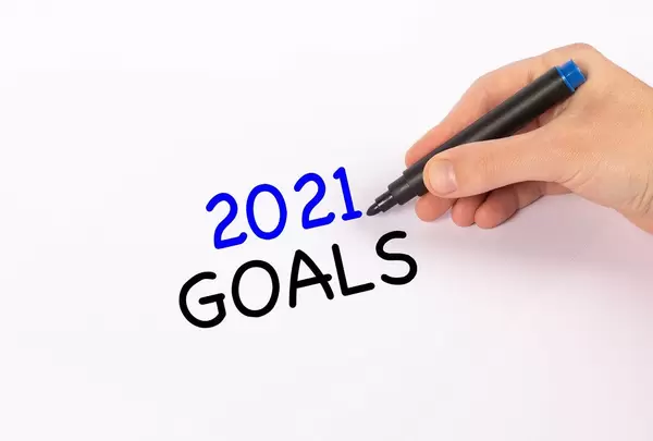 Hand mit Edding-Marker schreibt "2021 goals" (Ziele für 2021)-Text