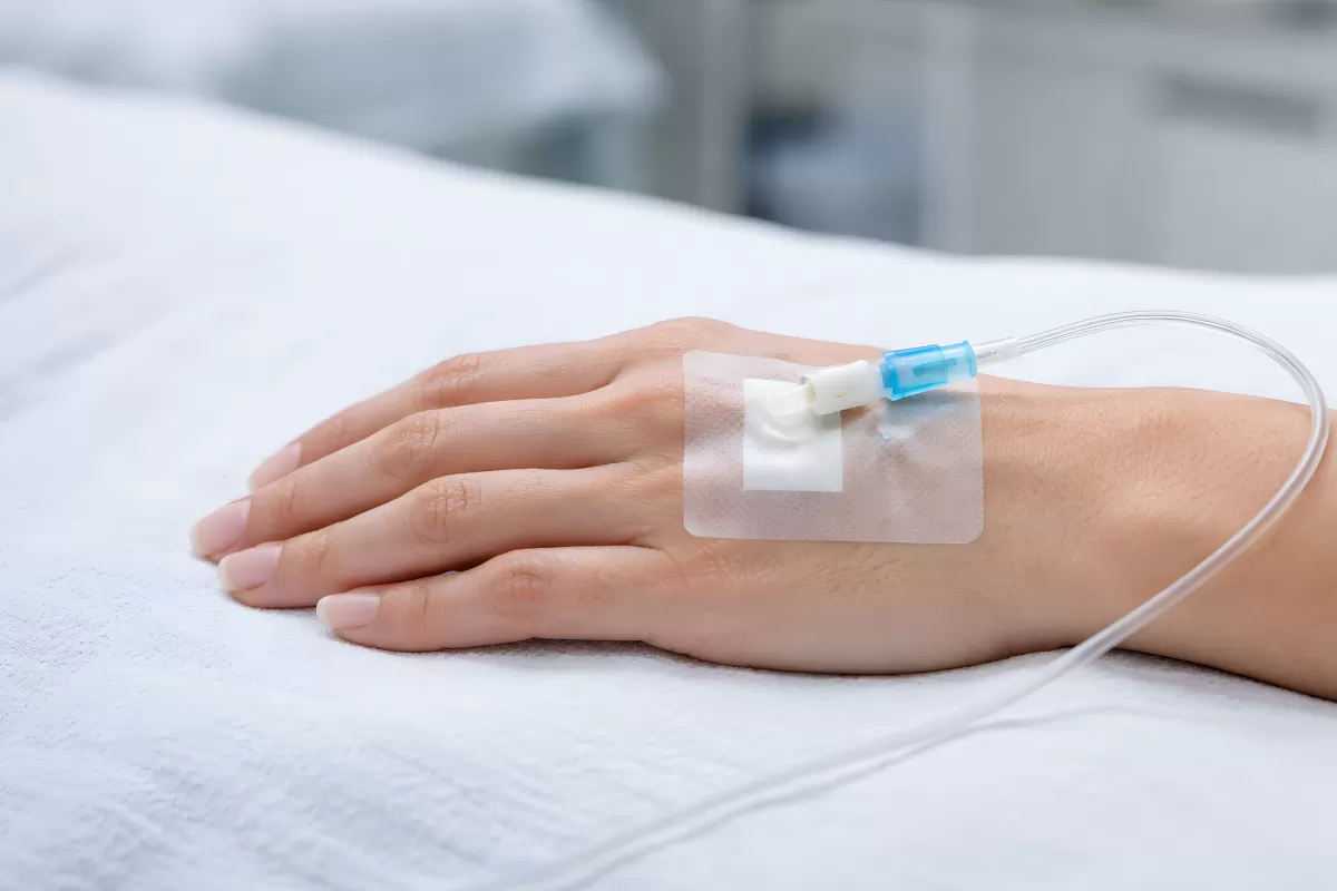 Hand mit intravenösem Infusionsschlauch im Krankenhaus