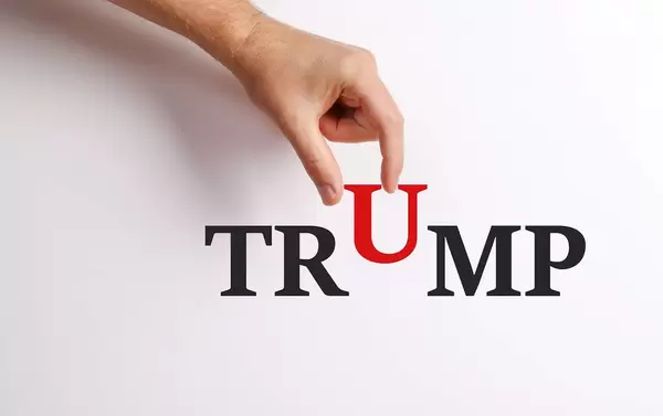 Hand pick up 'U' from Trump text