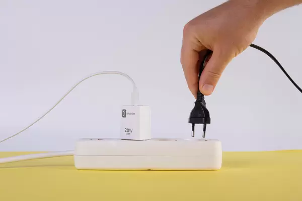 Hand pluging the wire into white extension cord