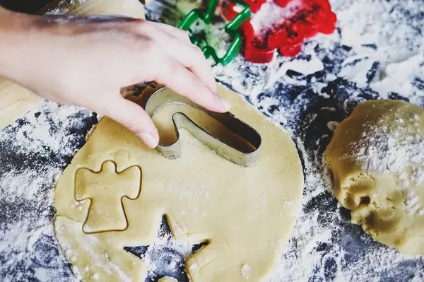 Hand pressing cookie cutter into dough