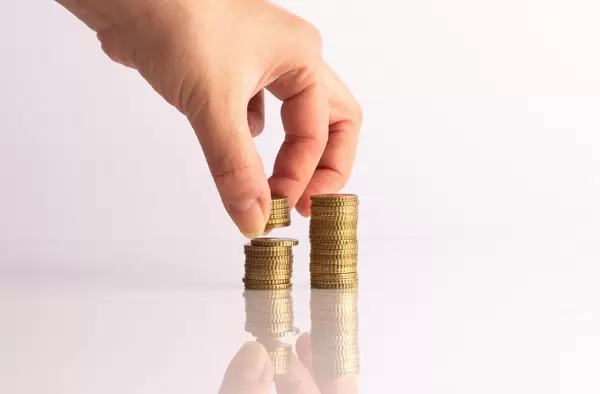 Hand putting coins on stack