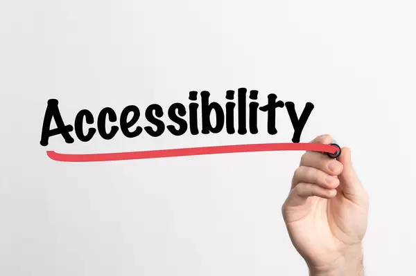 Hand schreibt Accessibility / Barrierefreiheit auf ein Whiteboard