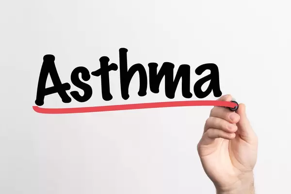 Hand schreibt Asthma auf ein Whiteboard