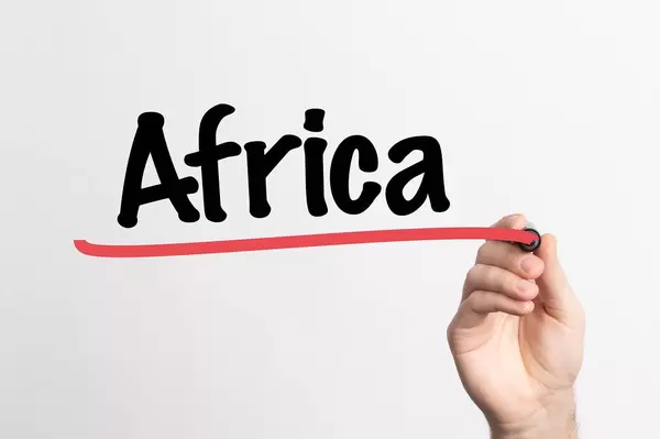 Hand schreibt das Wort "Afrika" auf ein Whiteboard