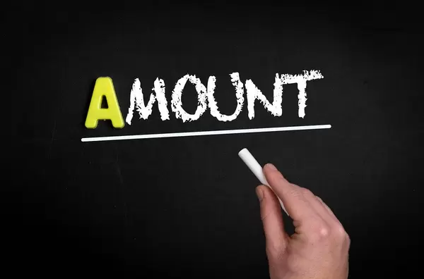 Hand schreibt das Wort "Amount" - Anzahl - mit Kreide auf eine schwarze Tafel