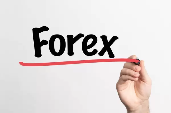 Hand schreibt das Wort "Forex" (Foreign Exchange) auf ein Whiteboard