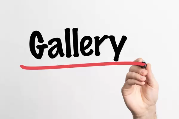 Hand schreibt das Wort "Gallerie" auf ein Whiteboard