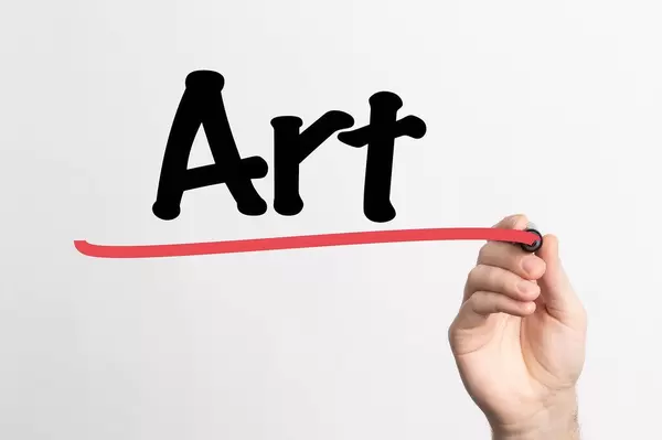 Hand schreibt das Wort "Kunst" auf ein Whiteboard