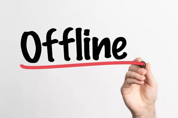 Hand schreibt das Wort "Offline" auf ein Whiteboard