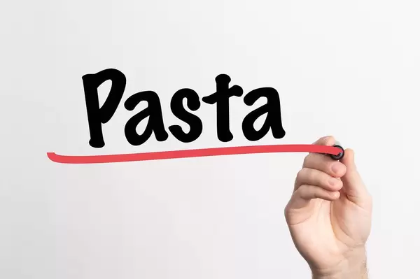 Hand schreibt das Wort "Pasta" auf ein Whiteboard