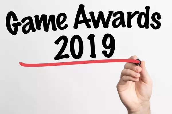 Hand schreibt das Wort  "Spielepreis 2019" auf ein Whiteboard