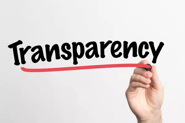 Hand schreibt das Wort "Transparenz" auf ein Whiteboard