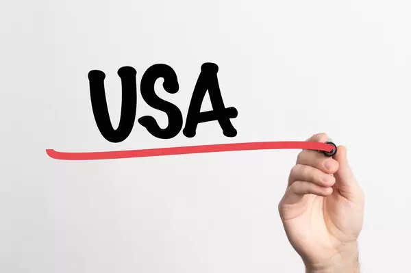 Hand schreibt das Wort "USA" auf ein Whiteboard
