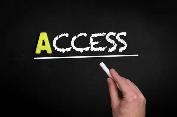 Hand schreibt “access” auf schwarze Tafel