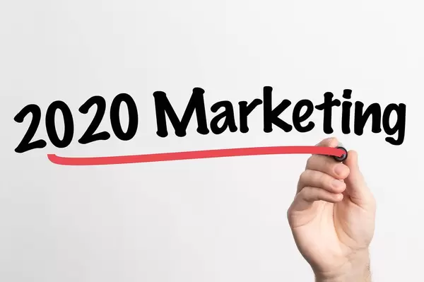 Hand schreibt "2020 Marketing" auf ein Whiteboard