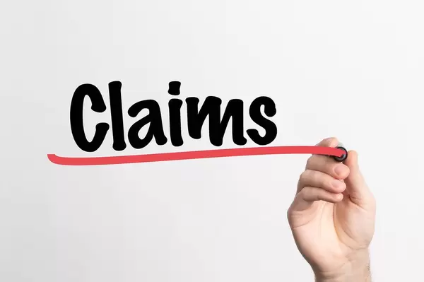 Hand schreibt "Ansprüche / Forderungen" auf ein Whiteboard