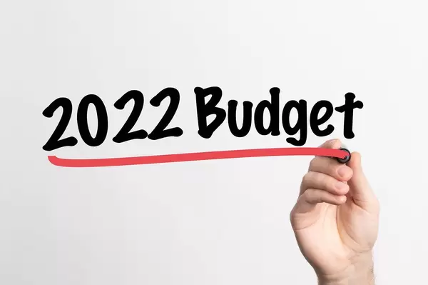 Hand schreibt "Budget für 2022" auf ein Whiteboard