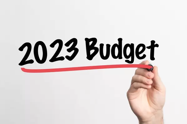 Hand schreibt "Budget für 2023" auf ein Whiteboard