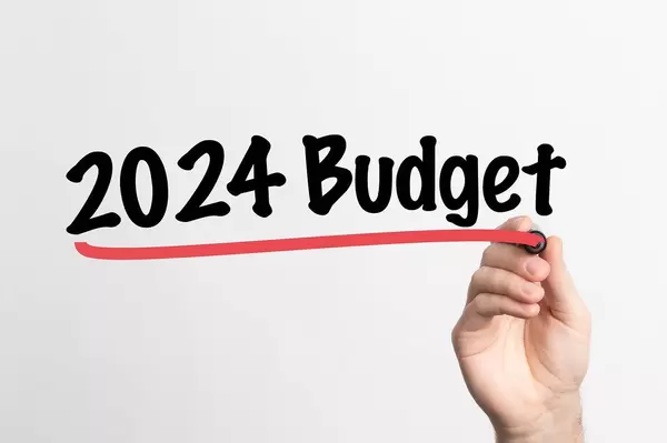 Hand schreibt "Budget für 2024" auf ein Whiteboard