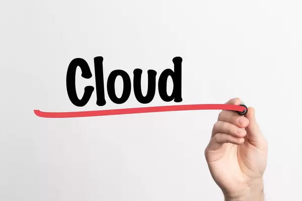 Hand schreibt "Cloud" auf ein Whiteboard