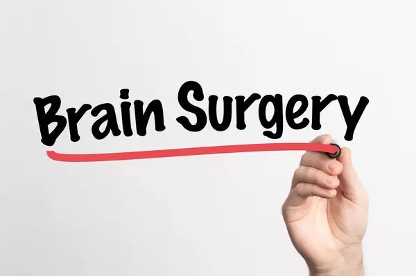 Hand schreibt "Gehirnchirurgie" auf ein Whiteboard