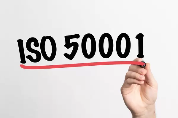 Hand schreibt "ISO 50001" auf ein Whiteboard
