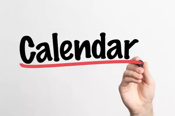 Hand schreibt "Kalender" auf ein Whiteboard