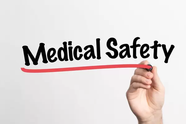 Hand schreibt "medizinische Sicherheit" auf ein Whiteboard