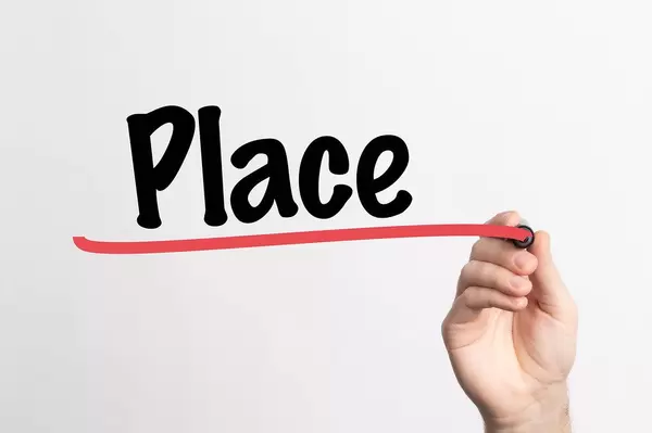 Hand schreibt "Platz / Ort" auf ein Whiteboard