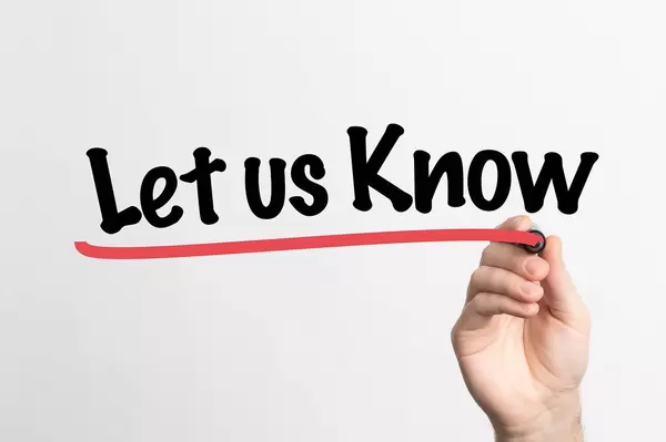 Hand schreibt "Sag uns Bescheid" auf ein Whiteboard