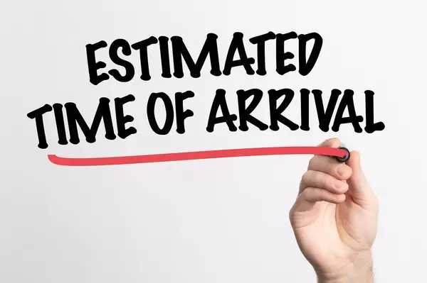 Hand schreibt  "voraussichtliche Ankunftszeit" auf ein Whiteboard