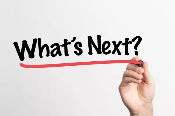 Hand schreibt "Was kommt als nächstes?" auf ein Whiteboard