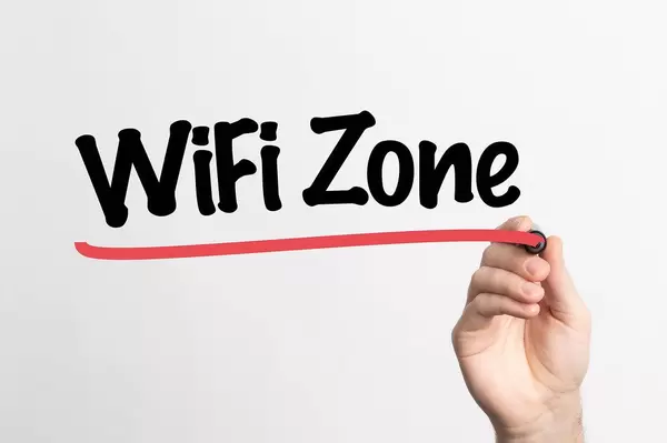 Hand schreibt "Wifi-Zone" auf ein Whiteboard