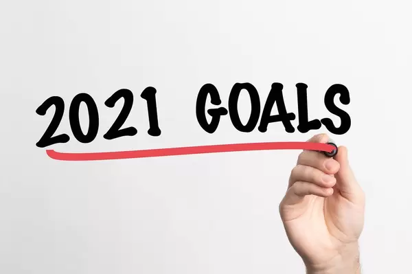 Hand schreibt "Ziele für 2021" auf ein Whiteboard