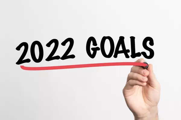 Hand schreibt "Ziele für 2022" auf ein Whiteboard