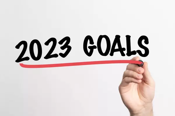 Hand schreibt "Ziele für 2023" auf ein Whiteboard