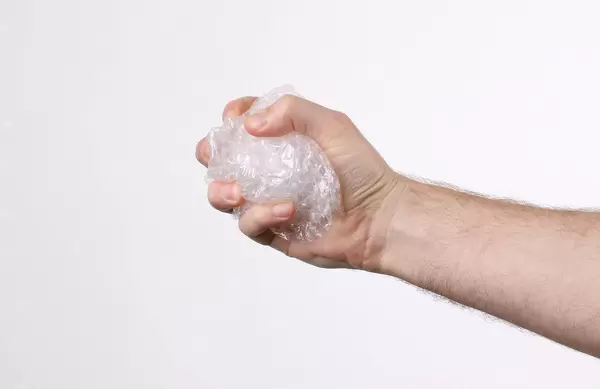 Hand squeezing bubble wrap