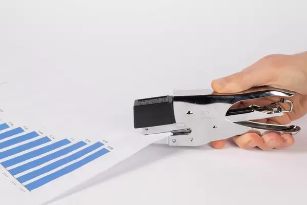 Hand stapling paper on white background