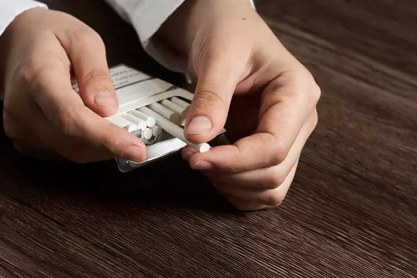 Hand taking out a cigarette from a cigarette pack