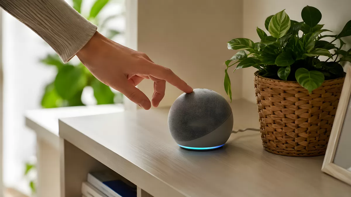 Hand tippt auf smarten Lautsprecher auf Holzregal