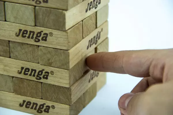 Hand Touching a Jenga Block