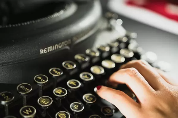 Hand typing on an old typewriter