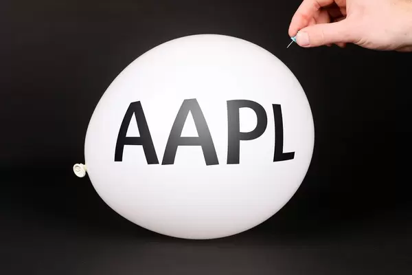 Hand uses a needle to burst a balloon with AAPL text