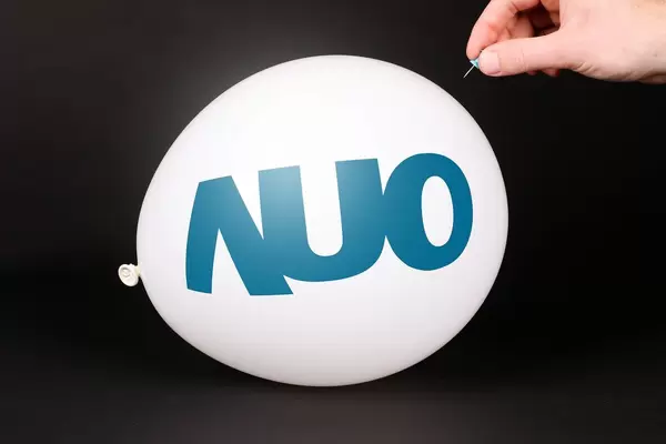 Hand uses a needle to burst a balloon with AU Optronics logo