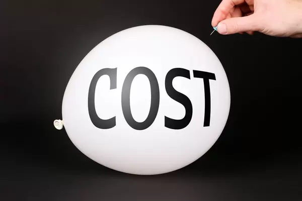 Hand uses a needle to burst a balloon with Cost text