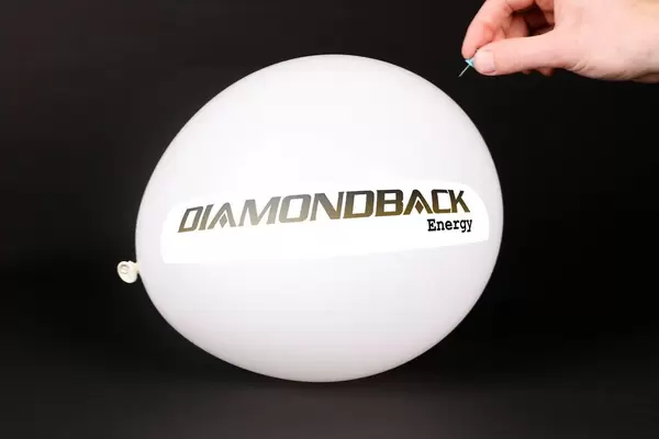 Hand uses a needle to burst a balloon with Diamondback Energy logo