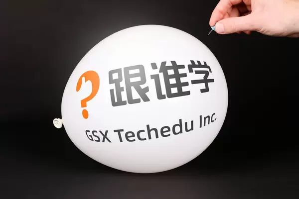 Hand uses a needle to burst a balloon with GSX Techedu logo