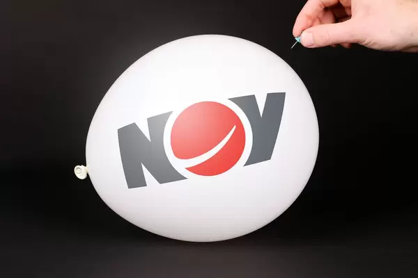 Hand uses a needle to burst a balloon with National Oilwell Varco logo